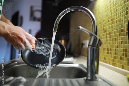 Man washing dish in sink at restaurant.People are washing the dishes too Cleaning solution