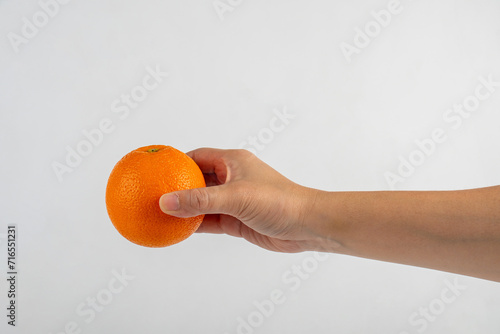 Hand holding orange isolated on white background