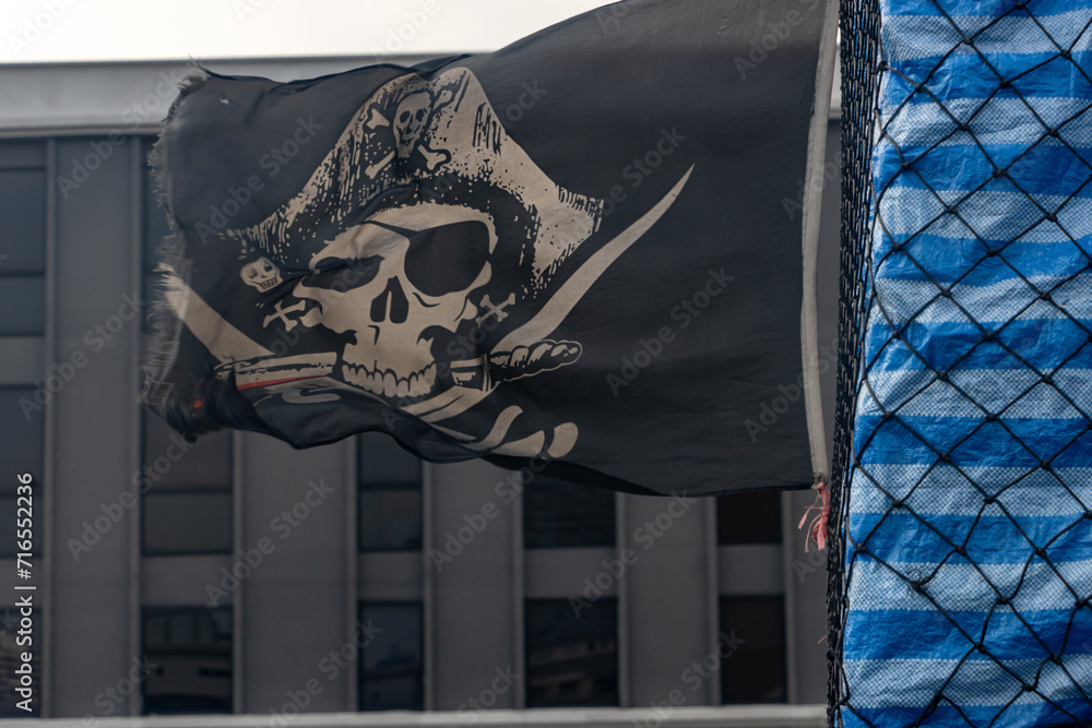 Fototapeta premium A pirate flag flies behind a moving pickup truck with cargo