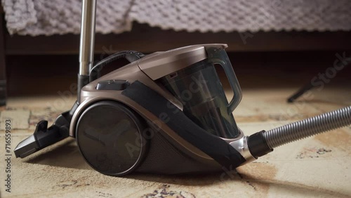 Cleaning the vacuum cleaner. A woman takes out a plastic flask containing dust after cleaning the house. photo