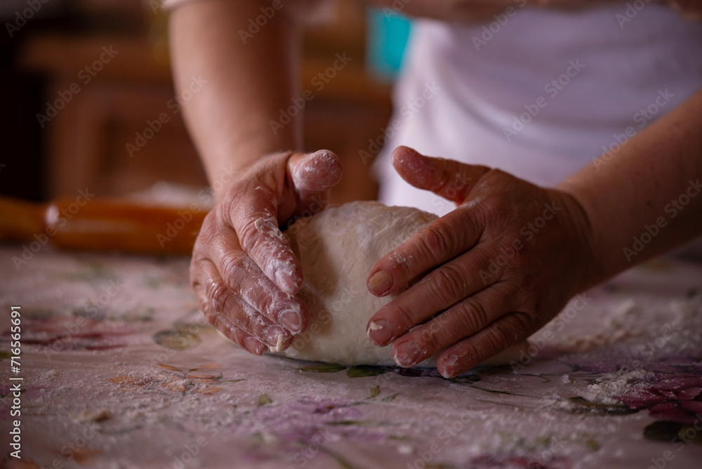 Cook's hands kneading dough for cakes. Preparing the flour for leavening