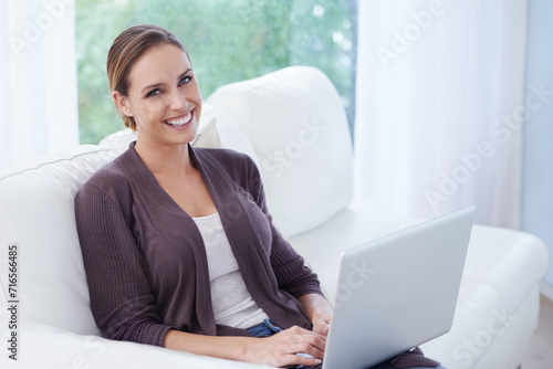 Woman, portrait or laptop on sofa for remote work, update blog post or search digital news on social media. Happy freelancer, computer or download copywriting subscription, for email research at home © Nicola Katie/peopleimages.com