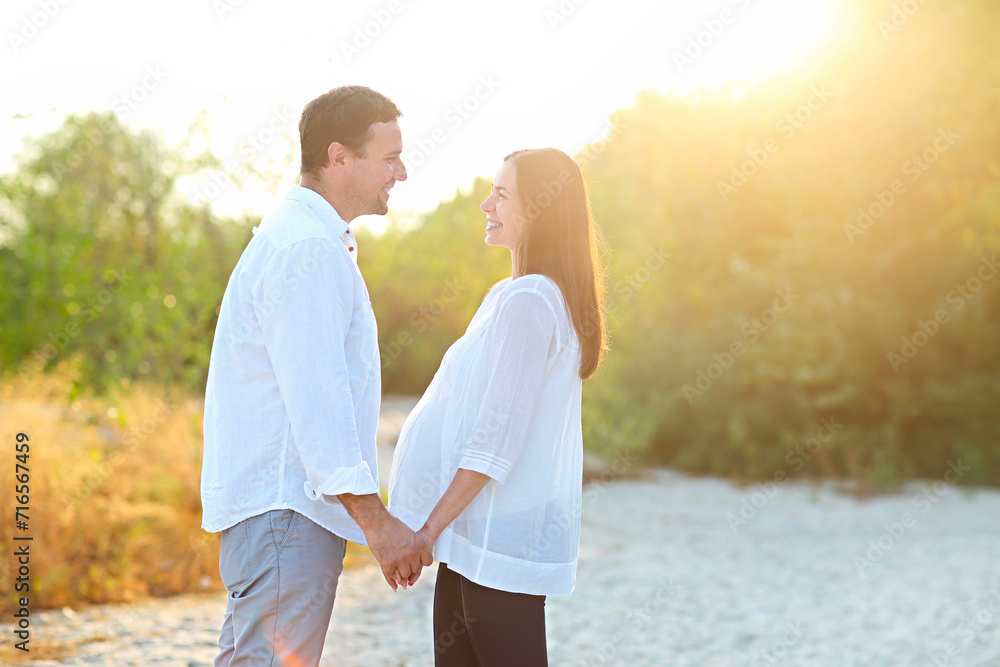 Young happy pregnant family on the beach Young happy pregnant family on the beach