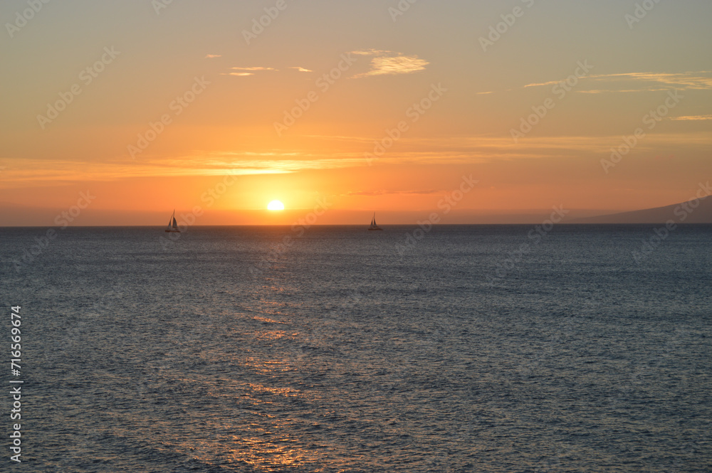 Sunset Over the Ocean with Sailboats in Hawaii Maui
