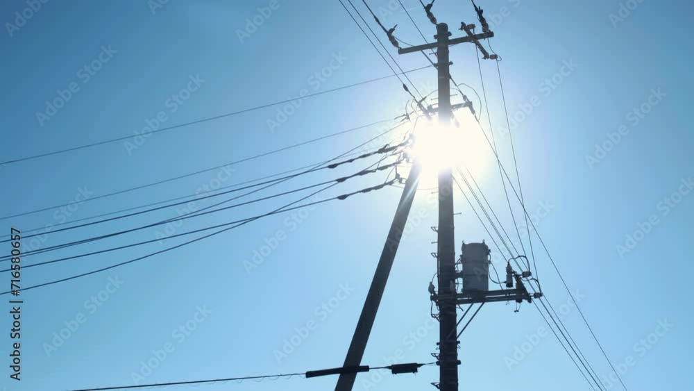 Sunlight through the electrical net of poles on a panorama of blue sky. Sunlight through the electrical net of poles on a panorama of blue sky.