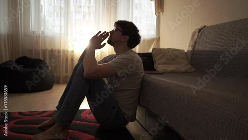 man sitting on bedroom floor and praying for divine help, asking for divine guidance during a crisis
