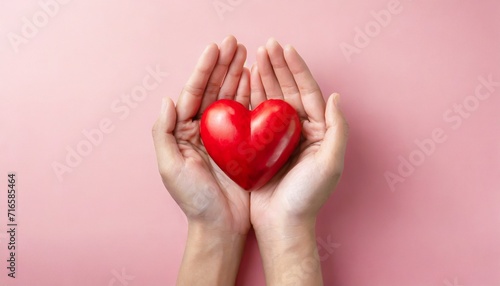 red heart in adult hands on pink background health care organ donation family life insurance world heart day brain stroke
