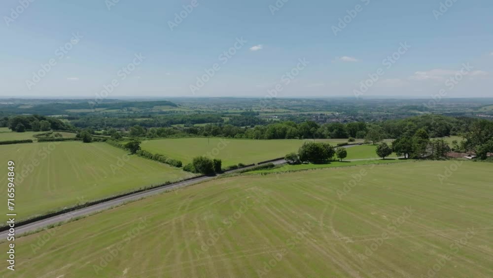 Slow Rising Aerial Drone of British Countryside with road in the middle Slow Rising Aerial Drone of British Countryside with road in the middle