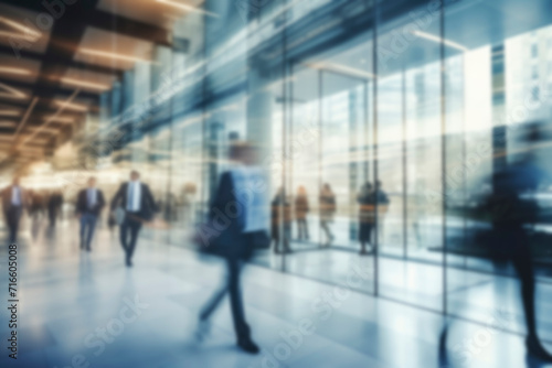 Abstract bokeh background. Blurred background business people in suits walk in hall of modern glass office, corridor of business center, shopping center, bank. Business concept