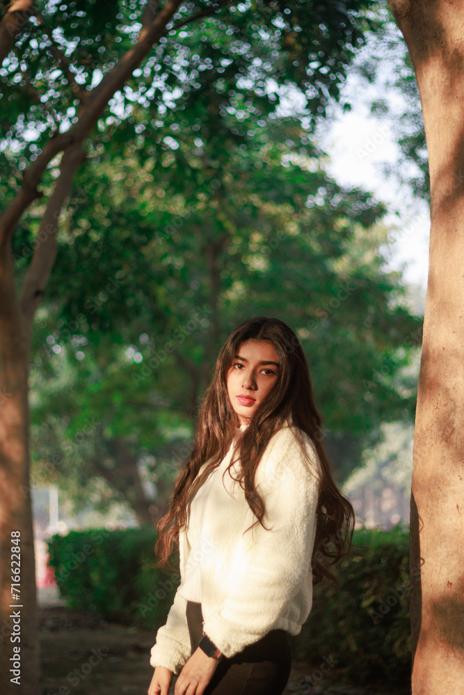 Autumn portrait of an attractive young woman in stylish glasses in a knitted fashionable white sweater in an elegant coat in a park on a background of trees with orange leaves.Girl walks in the forest Autumn portrait of an attractive young woman in stylish glasses in a knitted fashionable white sweater in an elegant coat in a park on a background of trees with orange leaves.Girl walks in the forest