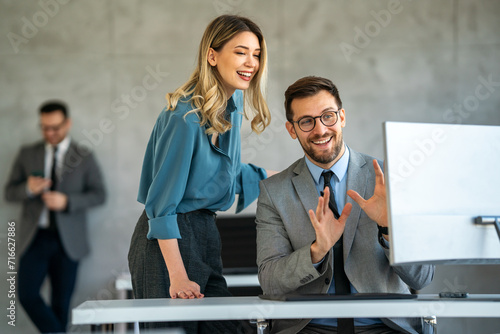 Portrait of successful business people working, talking together in corporate office during work.
