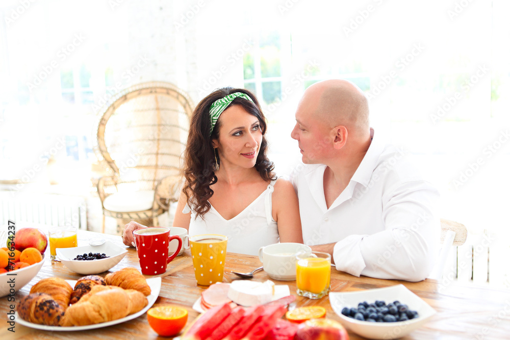 Loving tender pregnant couple at table with breakfast Loving tender pregnant couple at table with breakfast