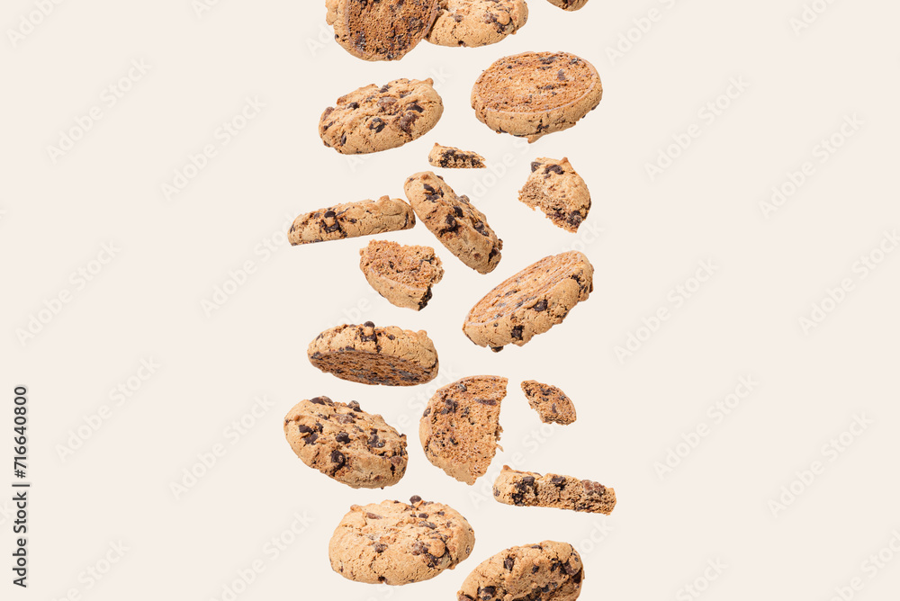 Chocolate cookie on a cream background. Aesthetic sweet food concept. Flying chocolate biscuits with copy space. Chocolate cookie on a cream background. Aesthetic sweet food concept. Flying chocolate biscuits with copy space.