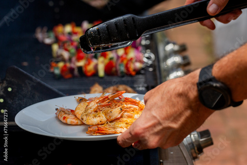 using tongs to take BBQ prawns off the barbie for Christmas lunch