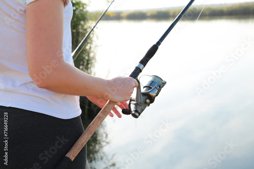 Close-up of a woman holding a fishing rod with a reel, sport fishing photo