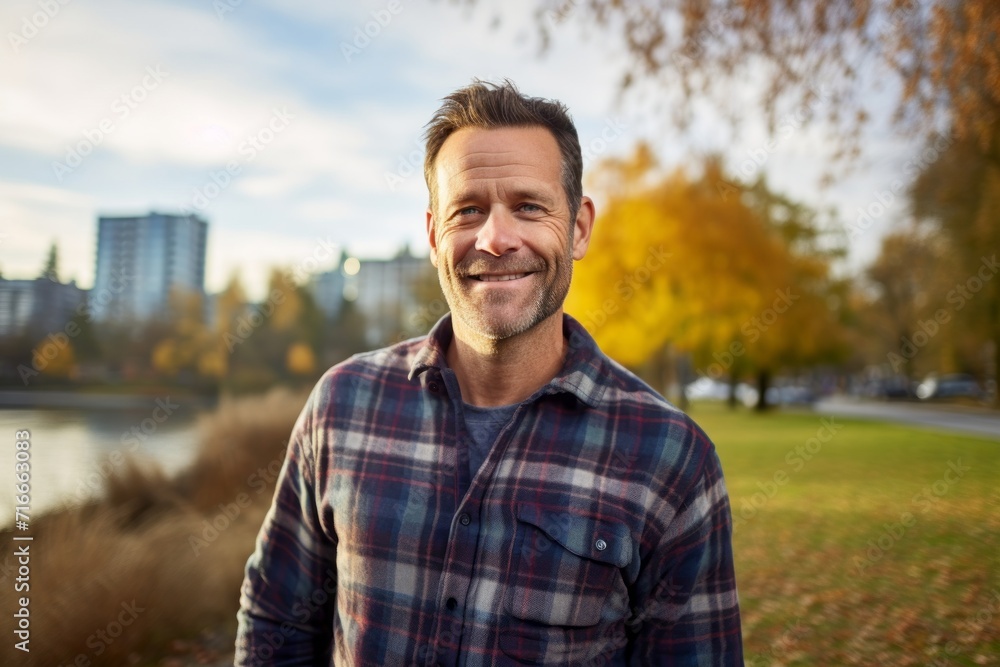 Portrait of a blissful man in his 40s wearing a comfy flannel shirt against a vibrant city park. AI Generation Portrait of a blissful man in his 40s wearing a comfy flannel shirt against a vibrant city park. AI Generation