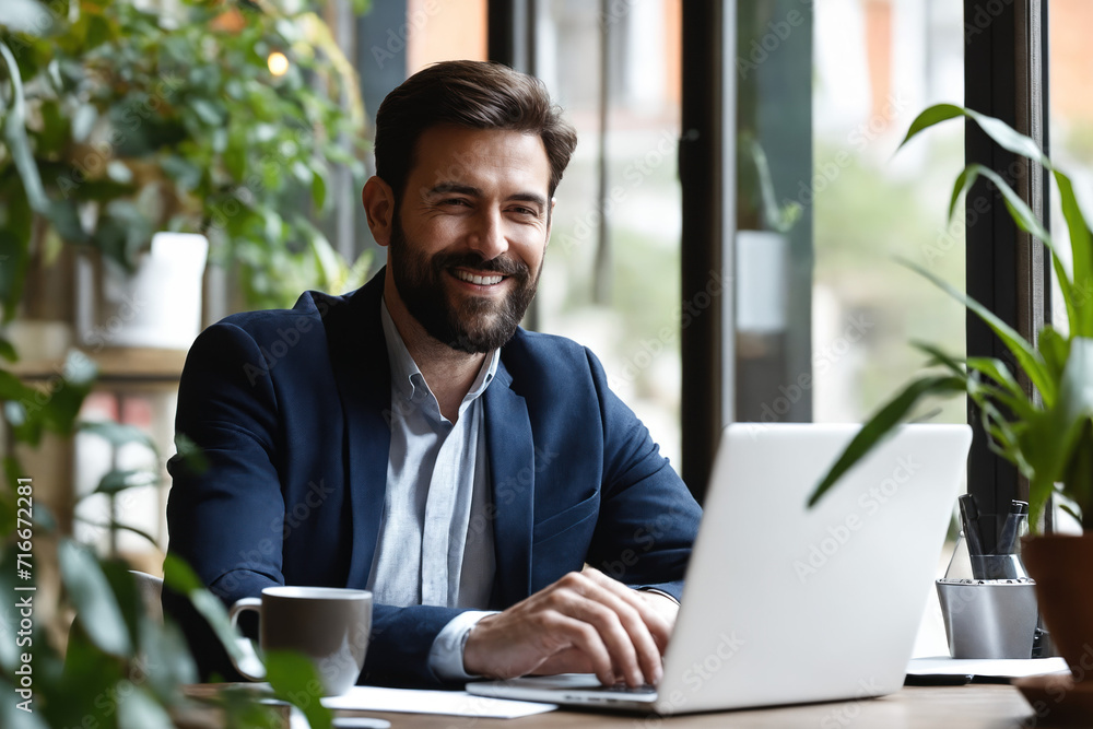 Portrait of cheerful businessman with laptop working in cozy workplace Portrait of cheerful businessman with laptop working in cozy workplace