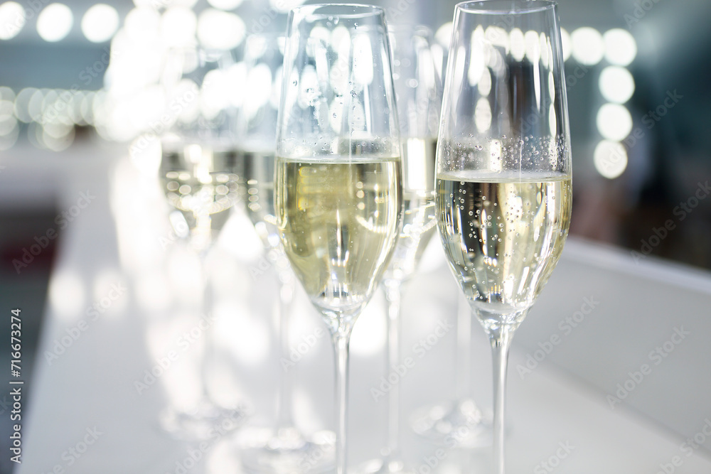 Champagne glasses on white background in bright lights Champagne glasses on white background in bright lights