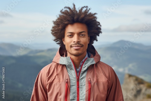 Portrait of a glad afro-american man in his 30s wearing a lightweight packable anorak against a panoramic mountain vista. AI Generation