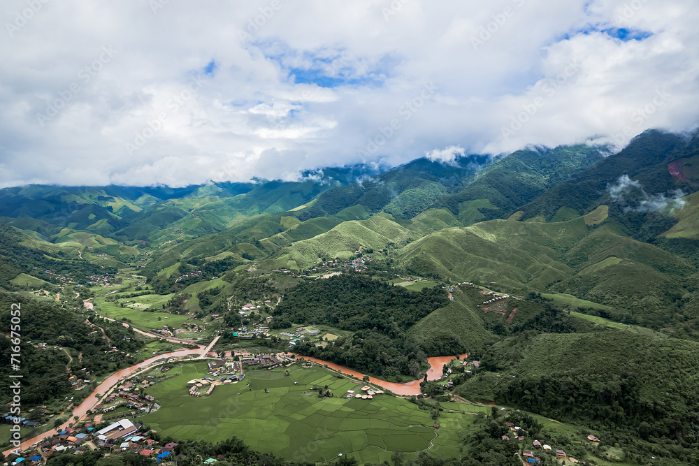 Beautiful village middle mountain and stunning landscape of green rice field at Nan province, Thailand.