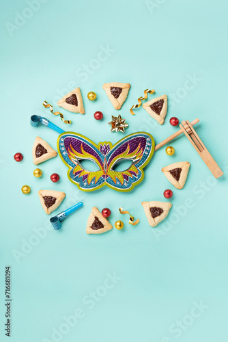 Purim Jewish Hamantaschen Cookies, Carnival Mask, Noisemaker on Blue Mint Green Background. Purim Celebration, Jewish Carnival Holiday Concept.