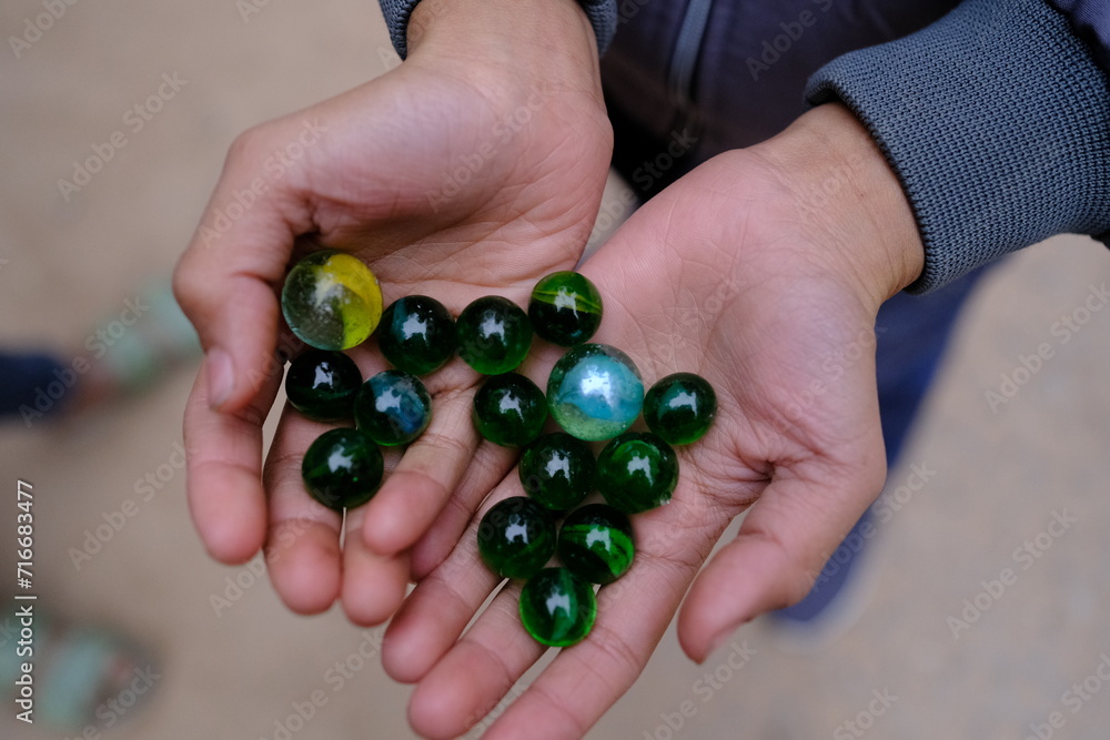 Closeup shot of beautiful marble balls in hands Closeup shot of beautiful marble balls in hands