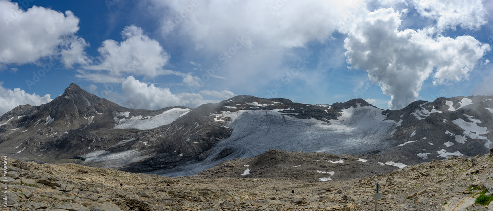 Panoramic view of a majestic mountain landscape with snow-capped peaks under a cloudy sky