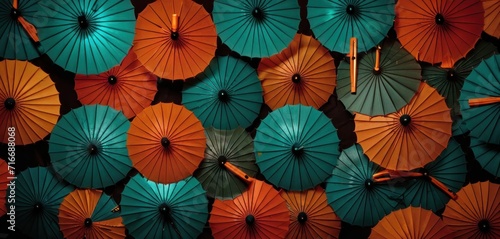  a group of orange and blue umbrellas sitting on top of each other in a wall of orange and blue umbrellas in front of a wall of orange and green umbrellas.
