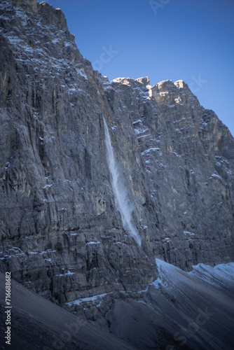 A majestic frozen waterfall cascading down a rugged mountain cliff.