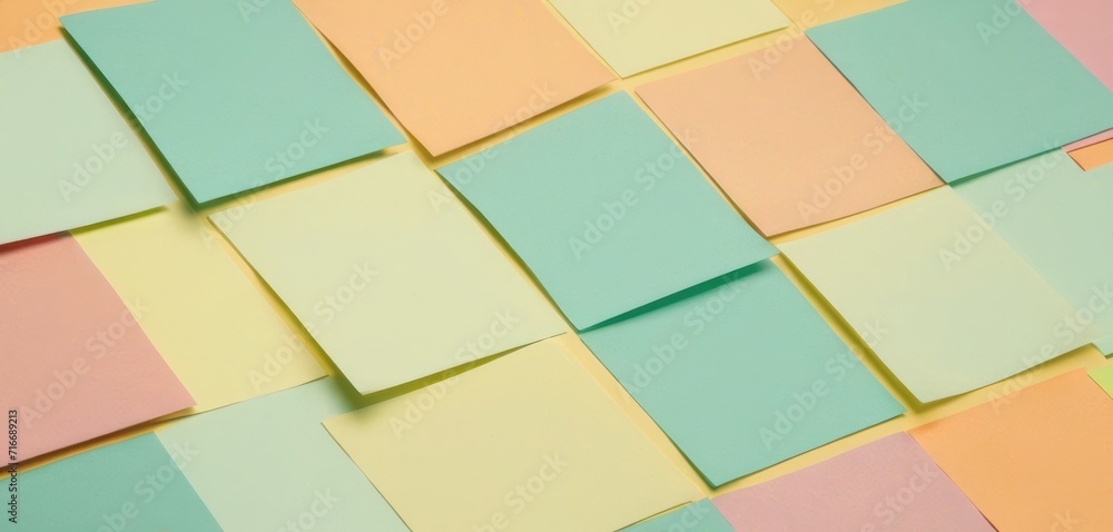  a close up of a wall with many squares of pastel colors and a black object in the middle of the wall with a black object in the middle of the photo.