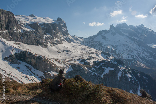 A hiker enjoying the view of a breathtaking snowy mountain landscape