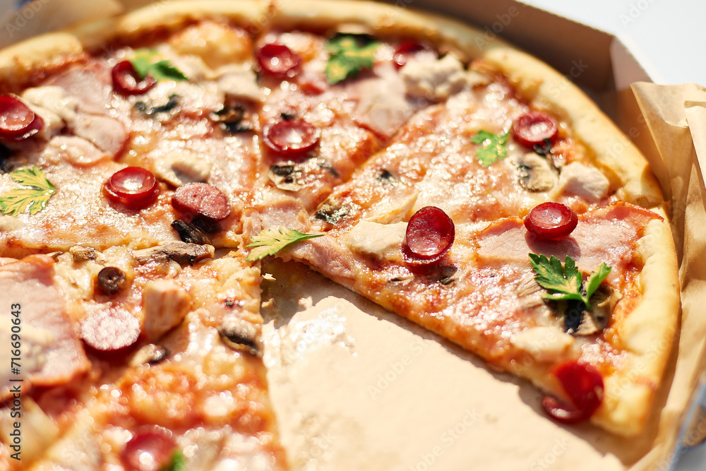 A freshly baked pizza with sliced tomatoes, cheese, mushrooms, and herbs is missing two slices, suggesting a shared meal at an outdoor picnic. A freshly baked pizza with sliced tomatoes, cheese, mushrooms, and herbs is missing two slices, suggesting a shared meal at an outdoor picnic.