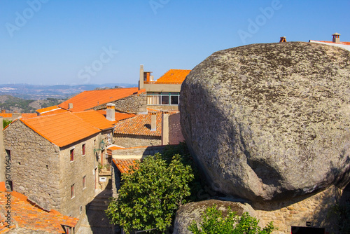photo, view of a village  street with stone houses on the mountain and a huge cobblestone in  Monsanto in Portugal, Europe