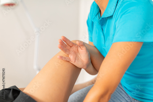A physical therapist manipulates the patient s knee and leg area to release muscle tension and pain