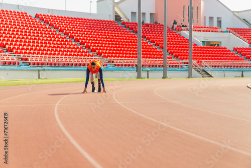 Asian para-athlete runner prosthetic leg on the track alone outside on a stadium track Paralympic running concept. 