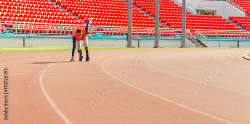 Asian para-athlete runner prosthetic leg on the track alone outside on a stadium track Paralympic running concept. 