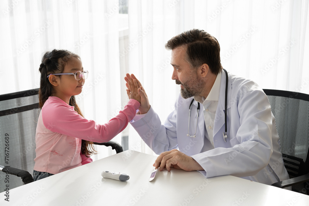 Obraz premium Patient Asia kid girl meeting and hi five caucasian doctor at hospital 