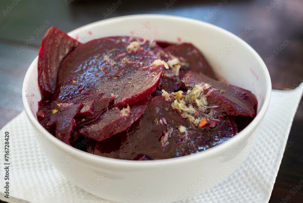 Beetroot salad, slices of boiled beet with garlic and olive oil, served in a bowl Beetroot salad, slices of boiled beet with garlic and olive oil, served in a bowl