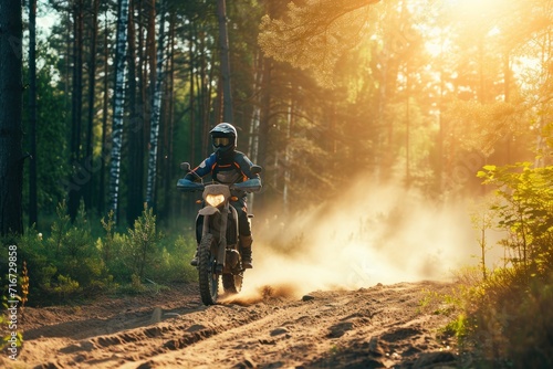 Motorcyclist rides on a dirt road through the forest in the rain. Motocross. Enduro. Extreme sport concept.