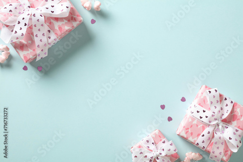 Valentine day greeting concept. Pink gift boxes with hearts on pastel blue background top view. Flat lay. © photoguns