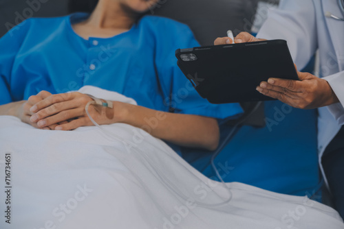 Asian Doctor make routine health check with patient in hospital ward