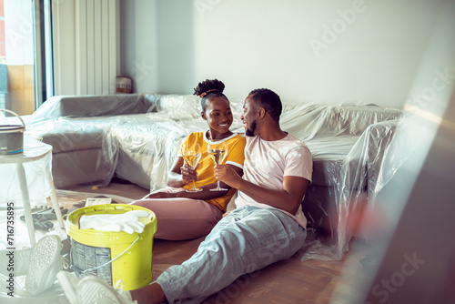 Happy young couple drinking wine after renovating the apartment photo