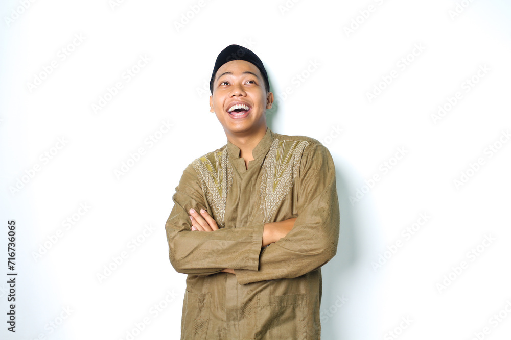 ecstatic asian muslim man laughing with folded arms wearing islamic dress isolated on white background ecstatic asian muslim man laughing with folded arms wearing islamic dress isolated on white background
