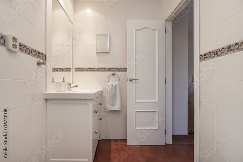 Small modern design bathroom with white wooden furniture with porcelain sink  terracotta flooring