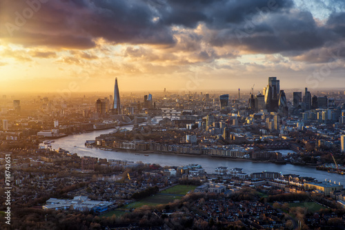 Dramatic sunset view of the iconic skyline of London, England, during a stormy day with river Thames and the modern Skyscrapers of the City