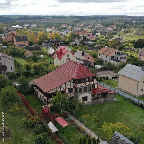 Picturesque cottage village in Europe with houses and private area (plots, vegetable gardens, fields) in bad weather, aerial view from a drone. Houses in English and Dutch style.