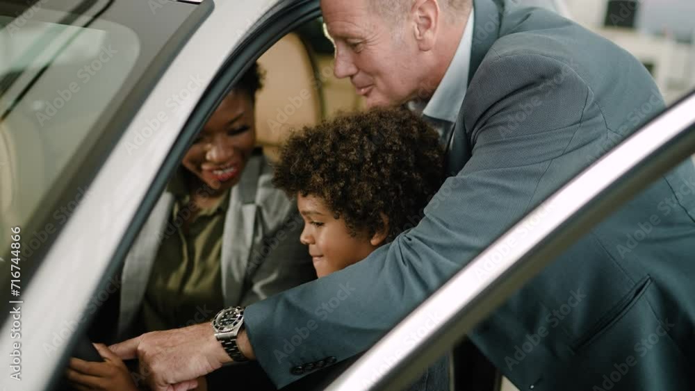 Multiethnic family testing out car at dealership Multiethnic family testing out car at dealership