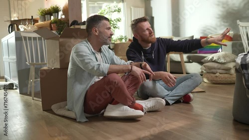 Young male gay couple planning for new home after moving in