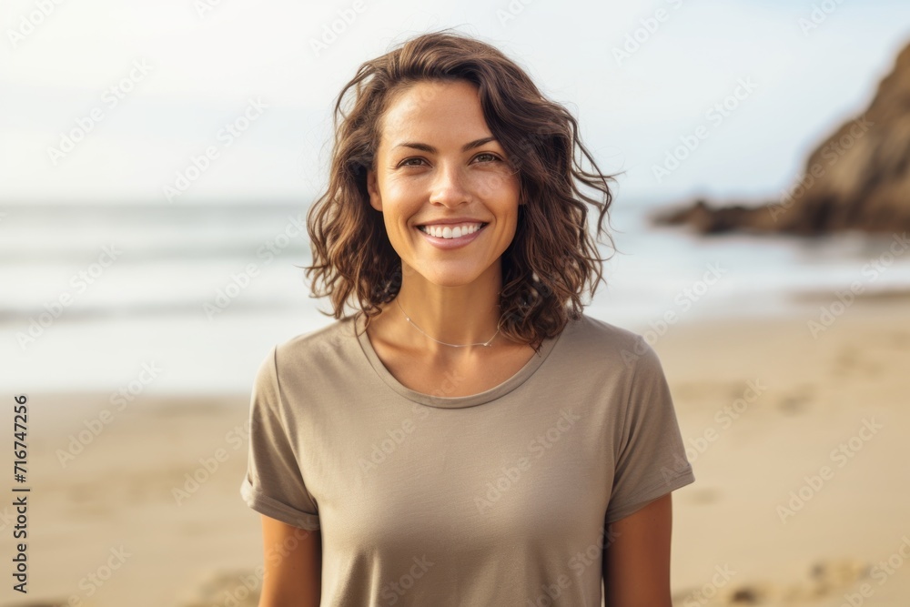Portrait of a grinning woman in her 30s dressed in a casual t-shirt against a sandy beach background. AI Generation Portrait of a grinning woman in her 30s dressed in a casual t-shirt against a sandy beach background. AI Generation