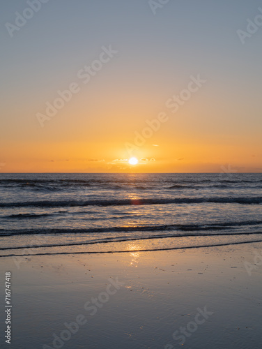 Mesmerizing beach sunset with vibrant colors, tranquil waves, and coastal beauty, ideal for relaxation, travel, golden skies